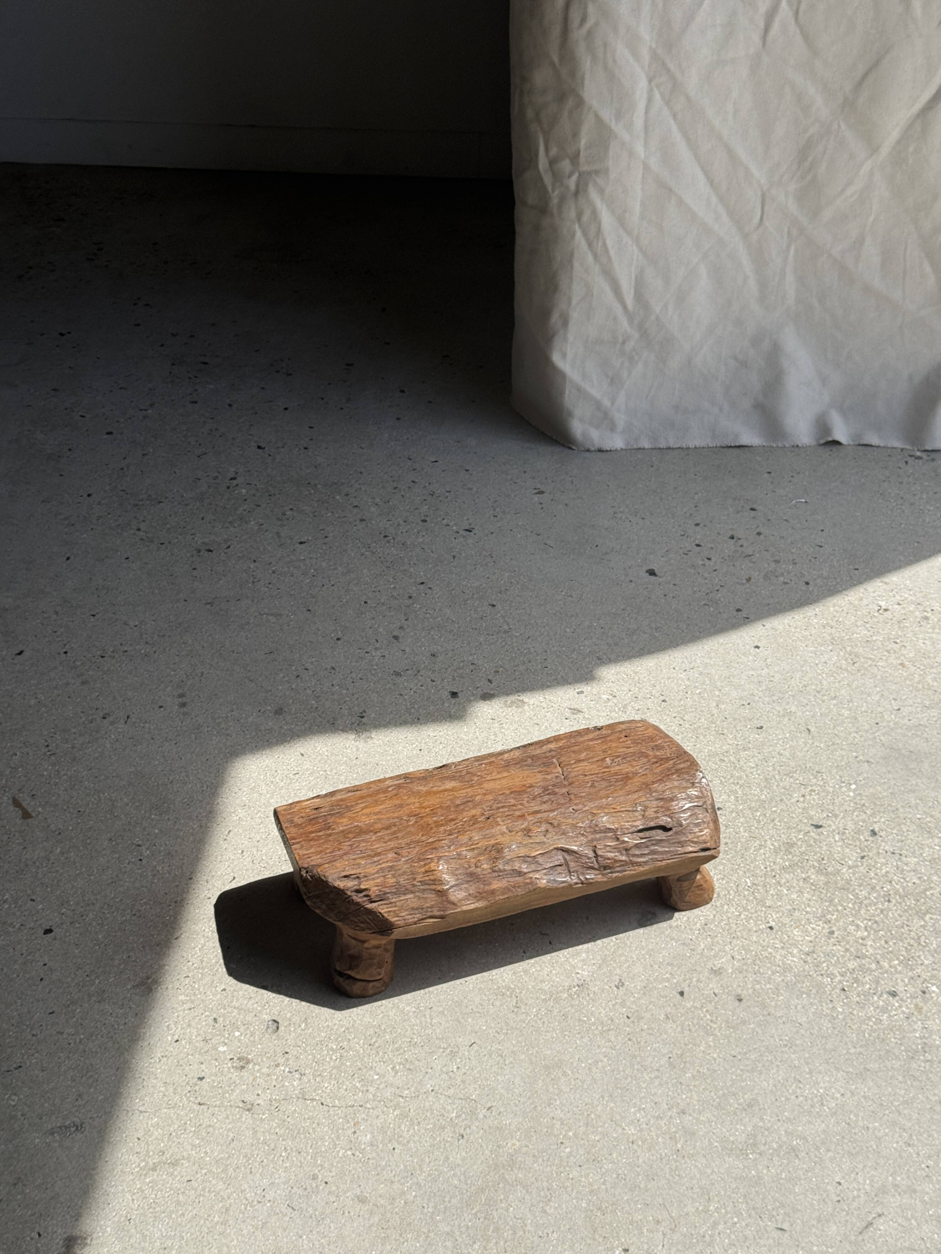 Small stool, footrest in blond teak, organic monoxyle with cut corners.