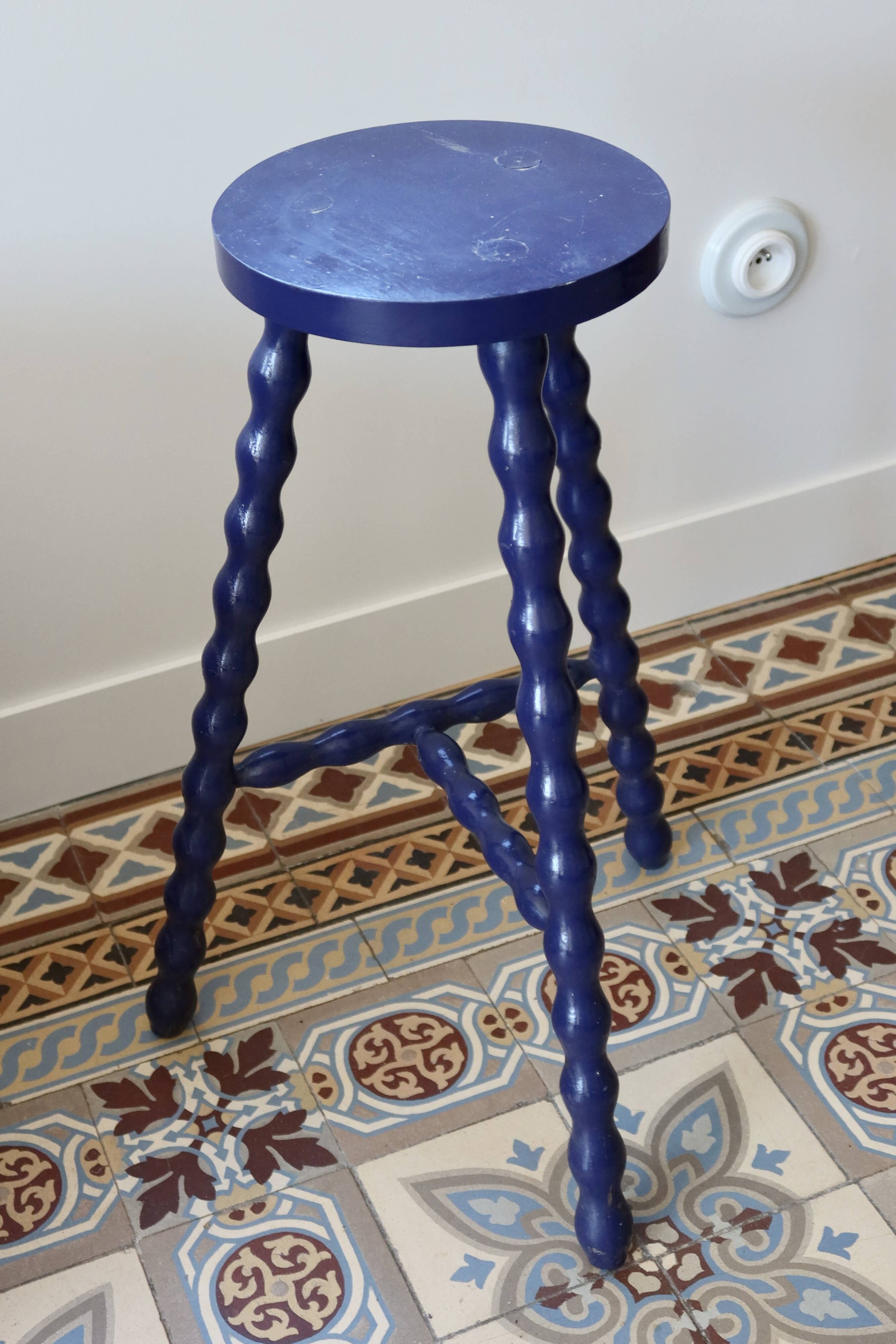 Vintage tripod stool made of turned wood, painted blue.