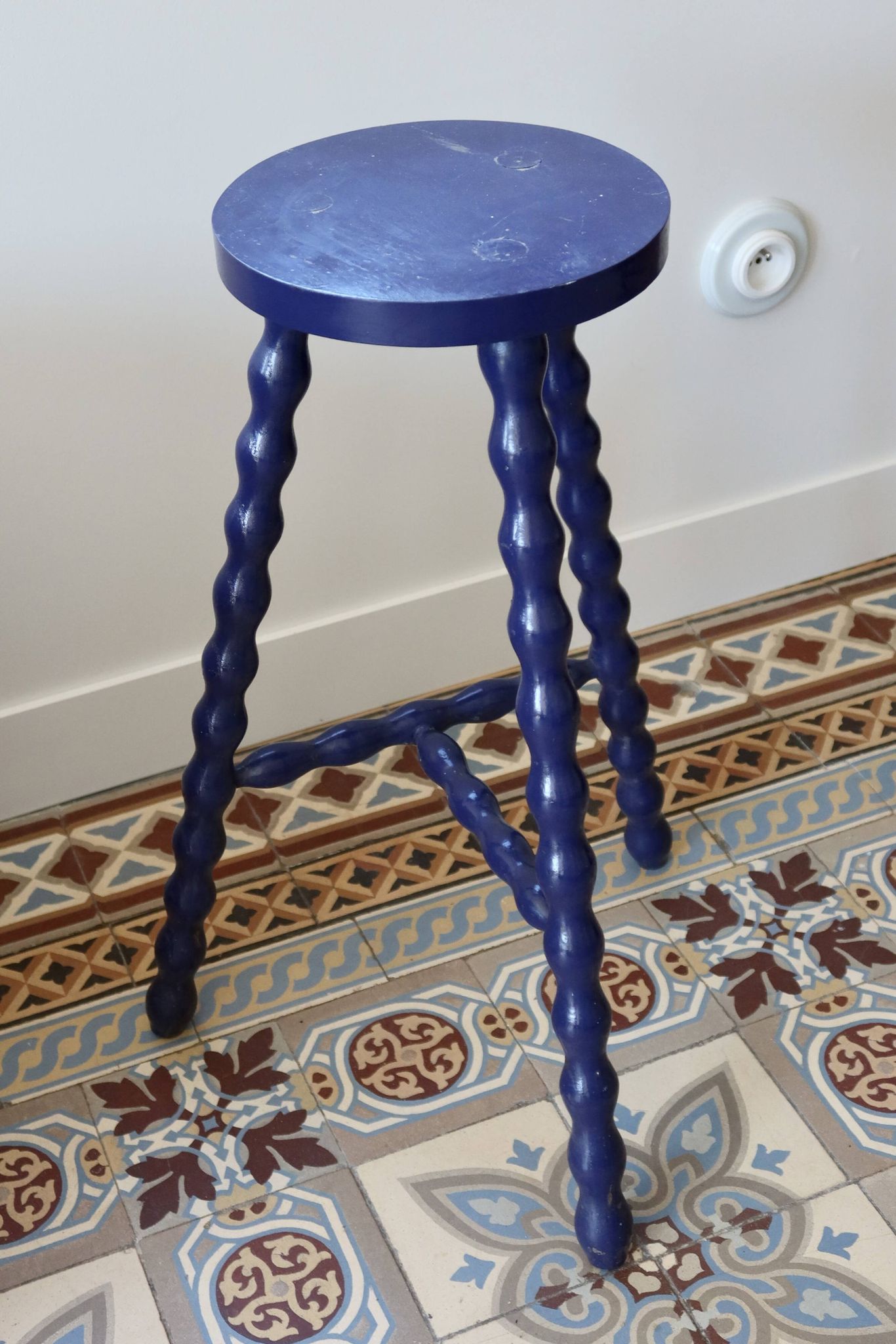Vintage tripod stool made of turned wood, painted blue.