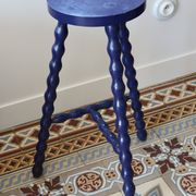Vintage tripod stool made of turned wood, painted blue.