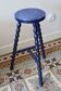 Vintage tripod stool made of turned wood, painted blue.