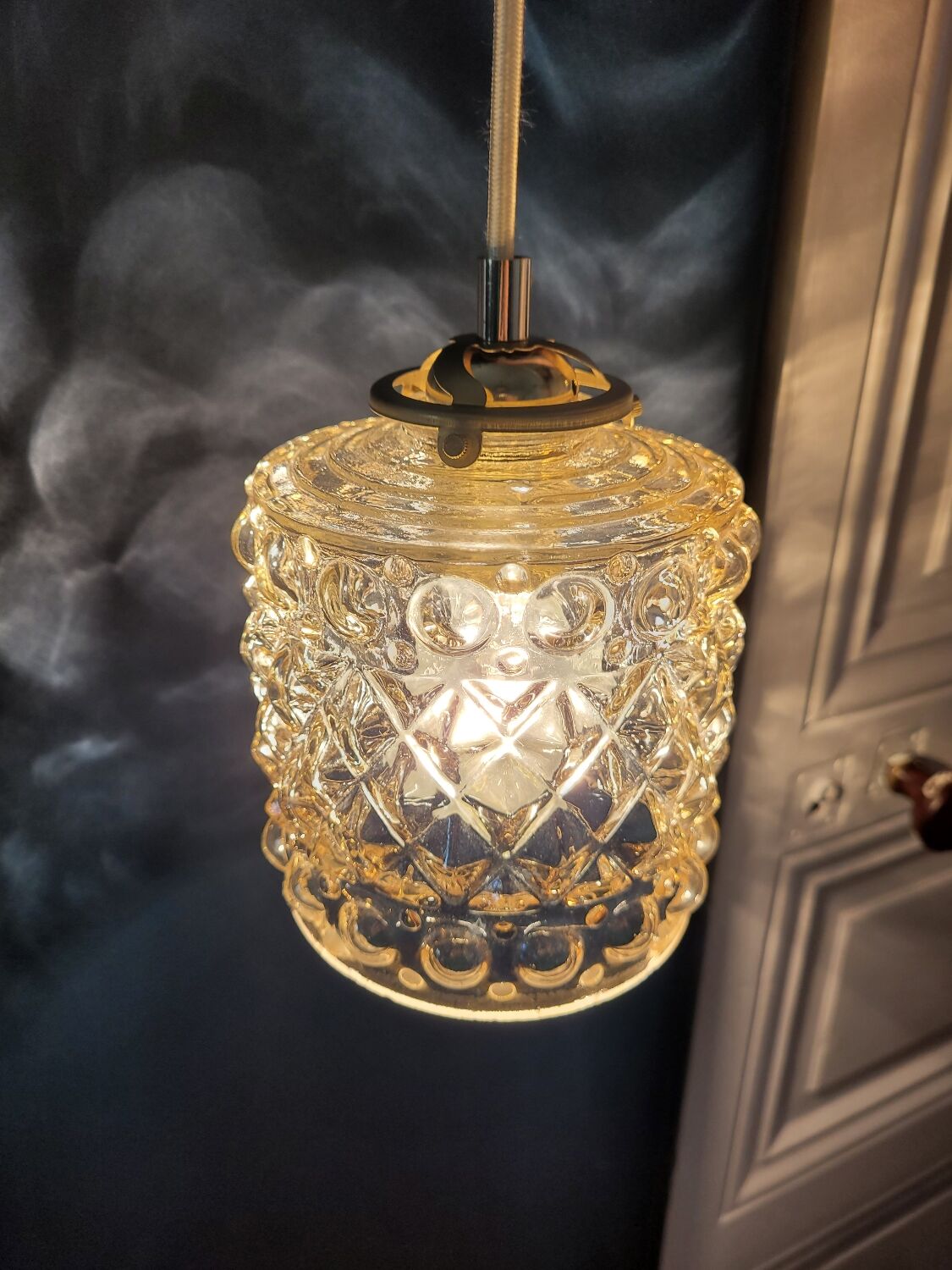 Moulded glass lamp with a cubic-spherical relief design.