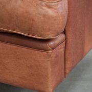Light cognac-coloured English wingback armchair made of cowhide leather