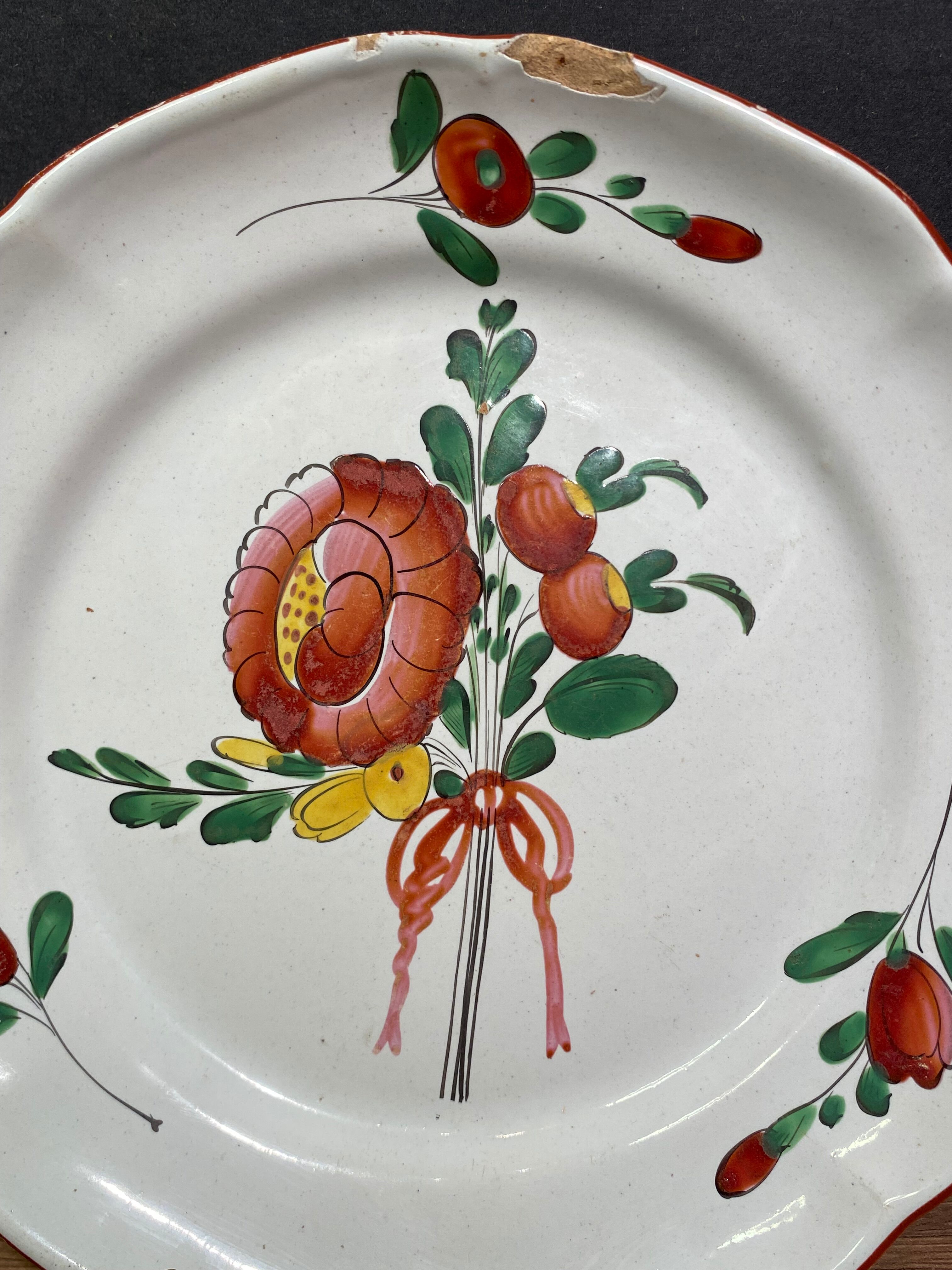 Assiette en faïence de l'Est XVIII-XIXe, décor floral enrubanné