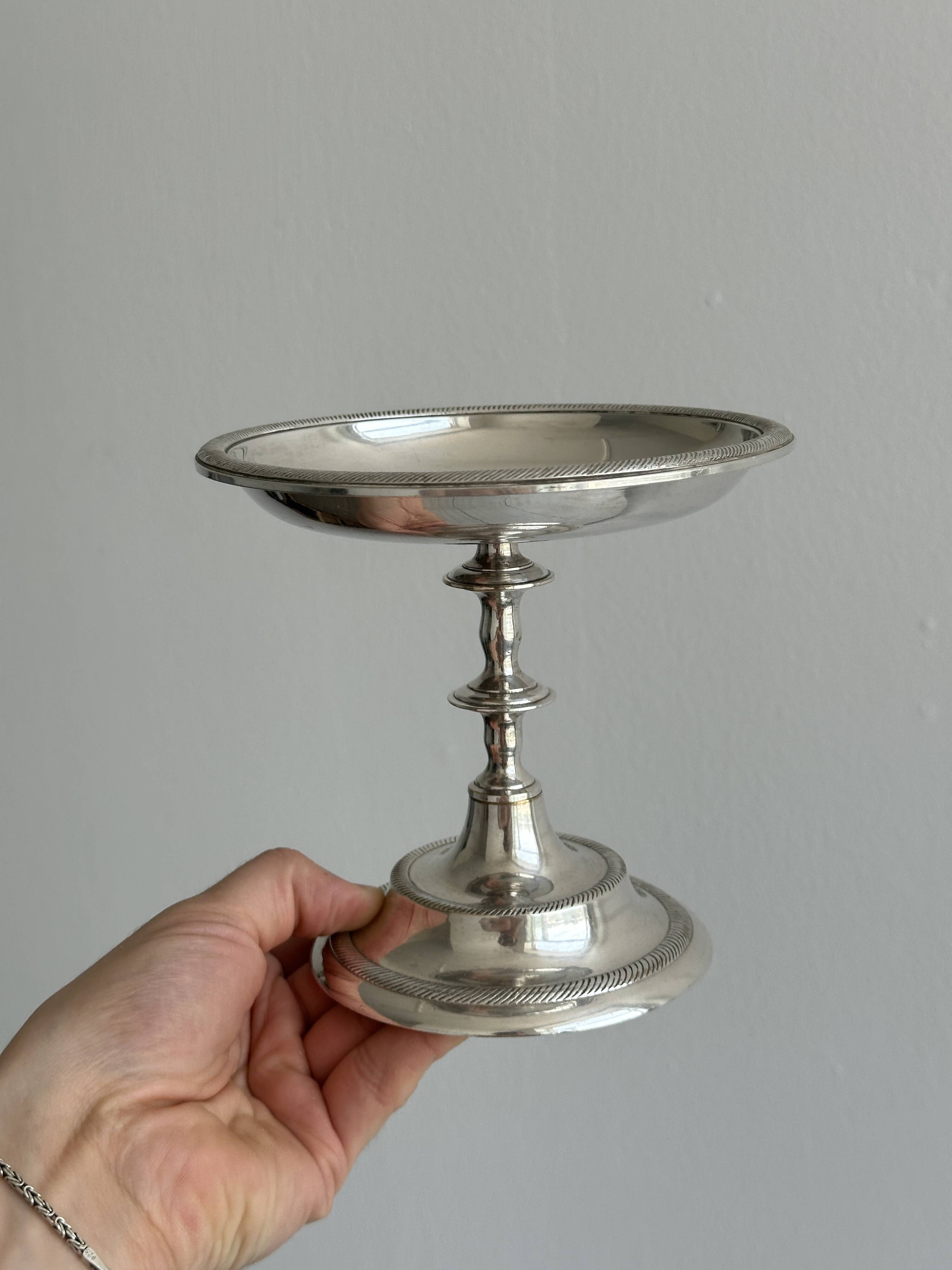 Silver-plated metal stand.