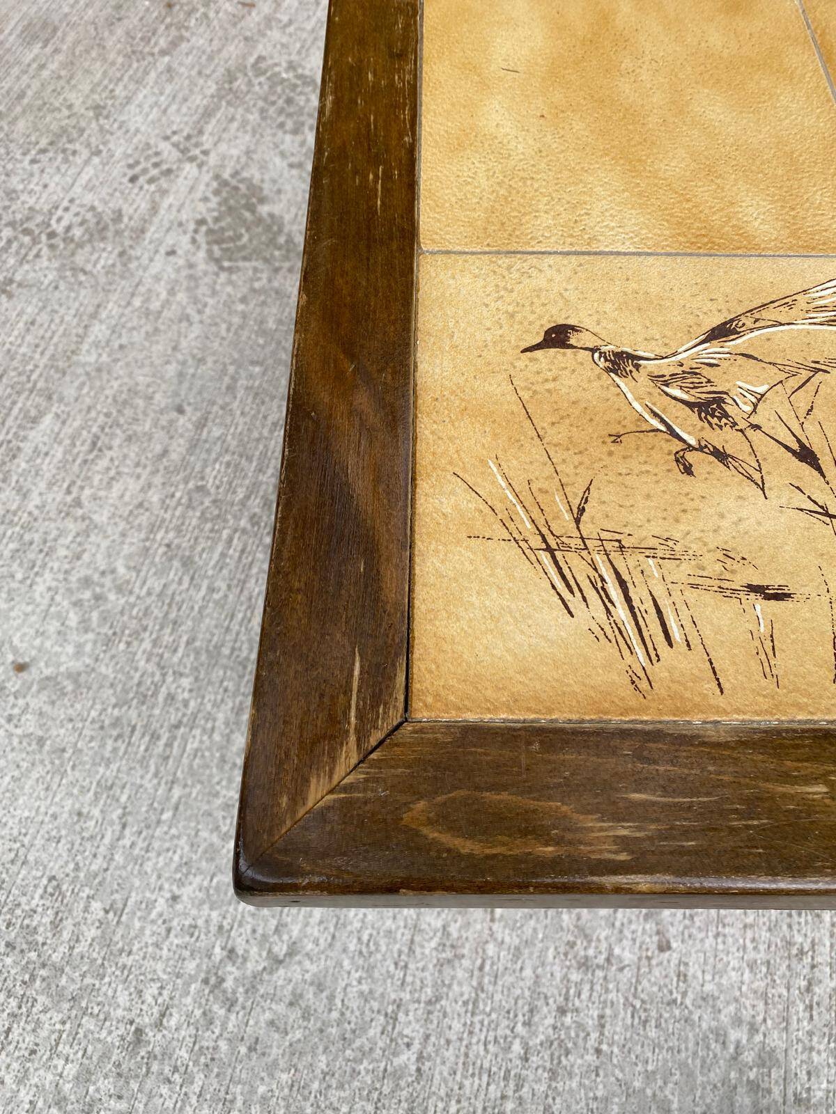 Vintage 70s coffee table with wood and ceramic tiles featuring bird and nature patterns.