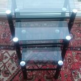 3 nesting tables in black metal with smoked glass tops.