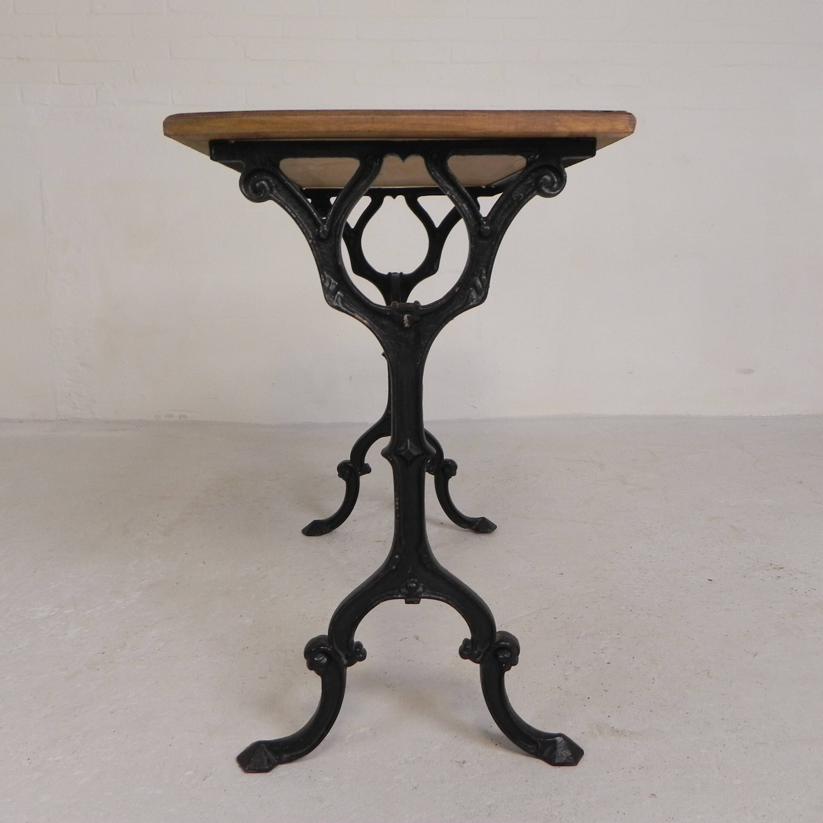 Bistro table with an oak top on a cast iron base, 1930s.
