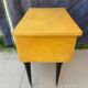 Vintage wooden bedside table from the 50s-60s with black tapered legs and brass tips.