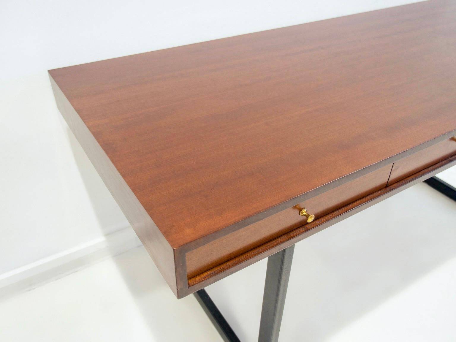 Wooden desk with drawers and black lacquered legs.
