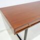 Wooden desk with drawers and black lacquered legs.