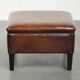 Large dark brown square ottoman made of sheepskin with black piping