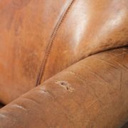 Sheepskin armchair with a beautiful vintage look and decorative nail finish