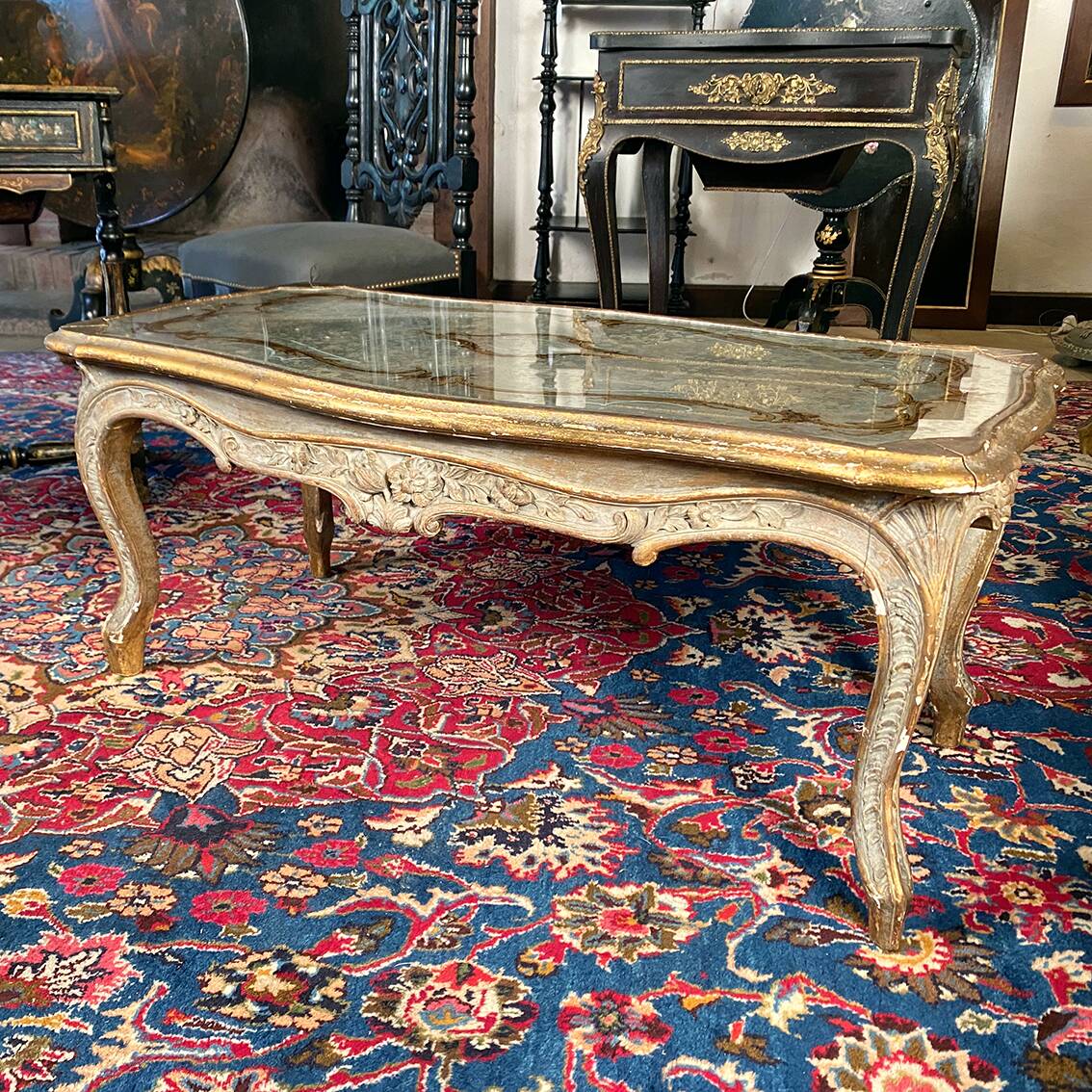 Louis XV style coffee table in carved wood with grey and gold highlights.