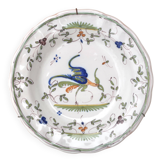 Hollow plate in Moustiers faience decorated with a bird, 19th century.
