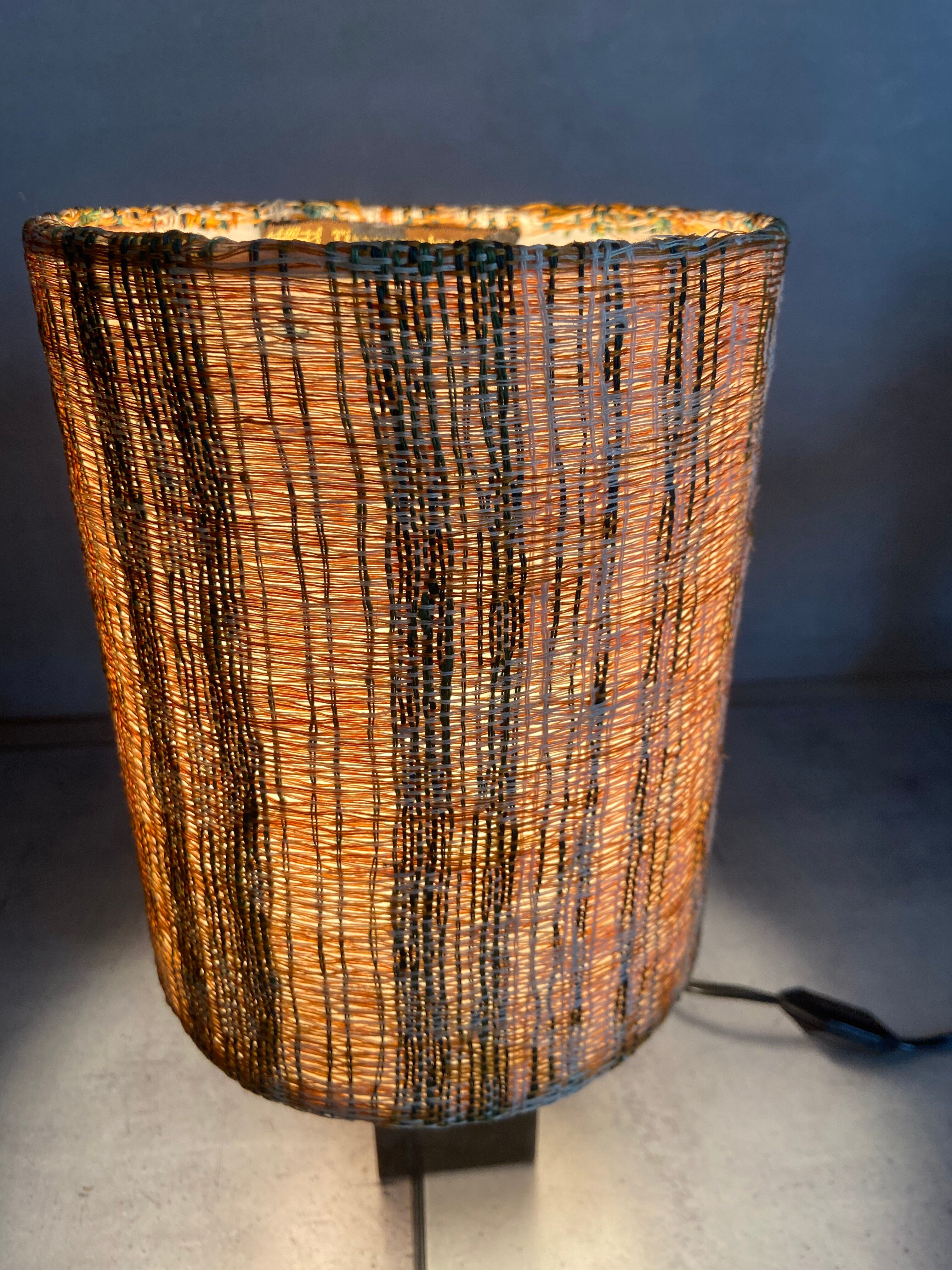 Small modernist table lamp with hand-woven shade.