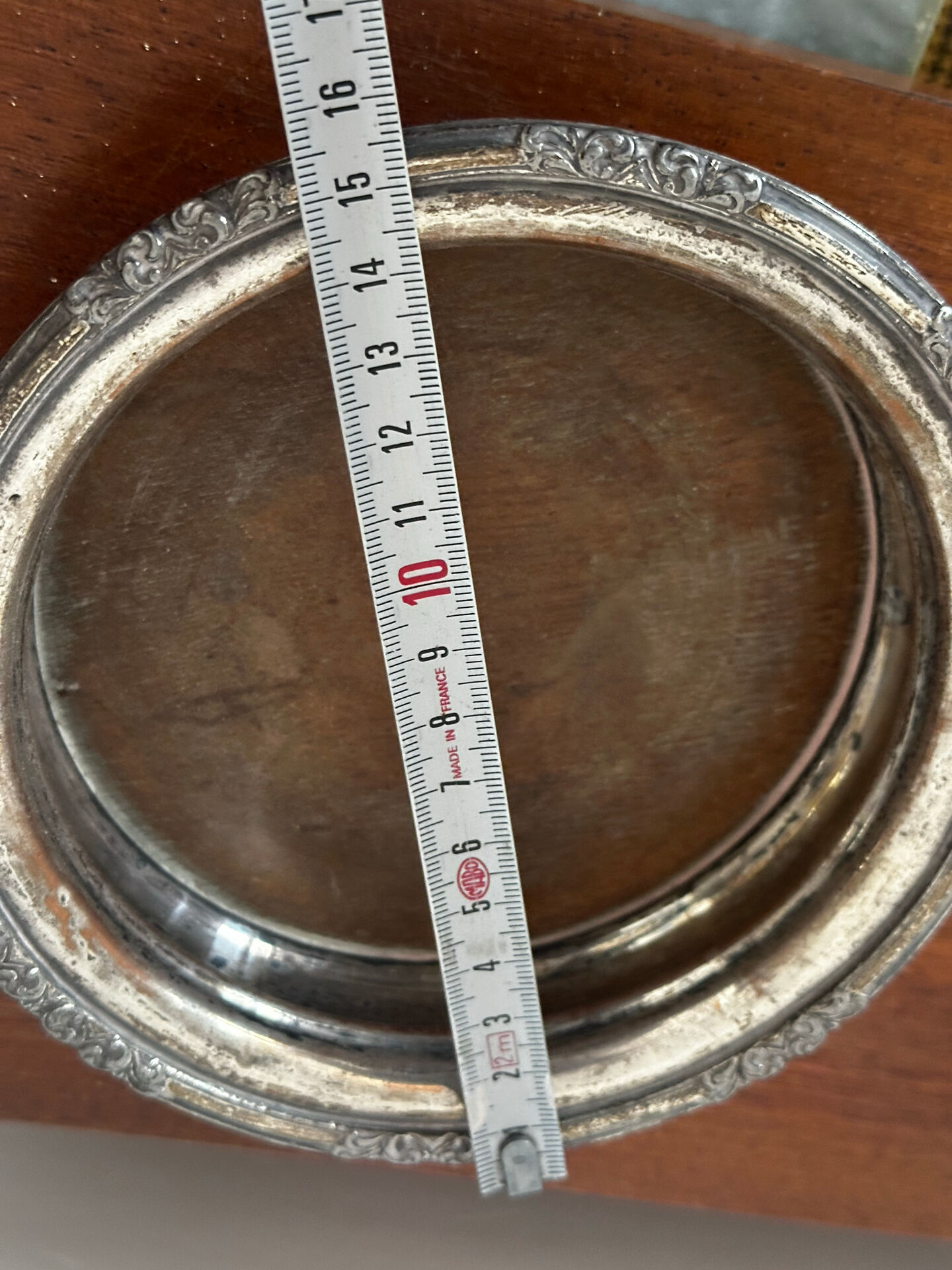 Antique silver-plated bottle coaster with floral decoration.