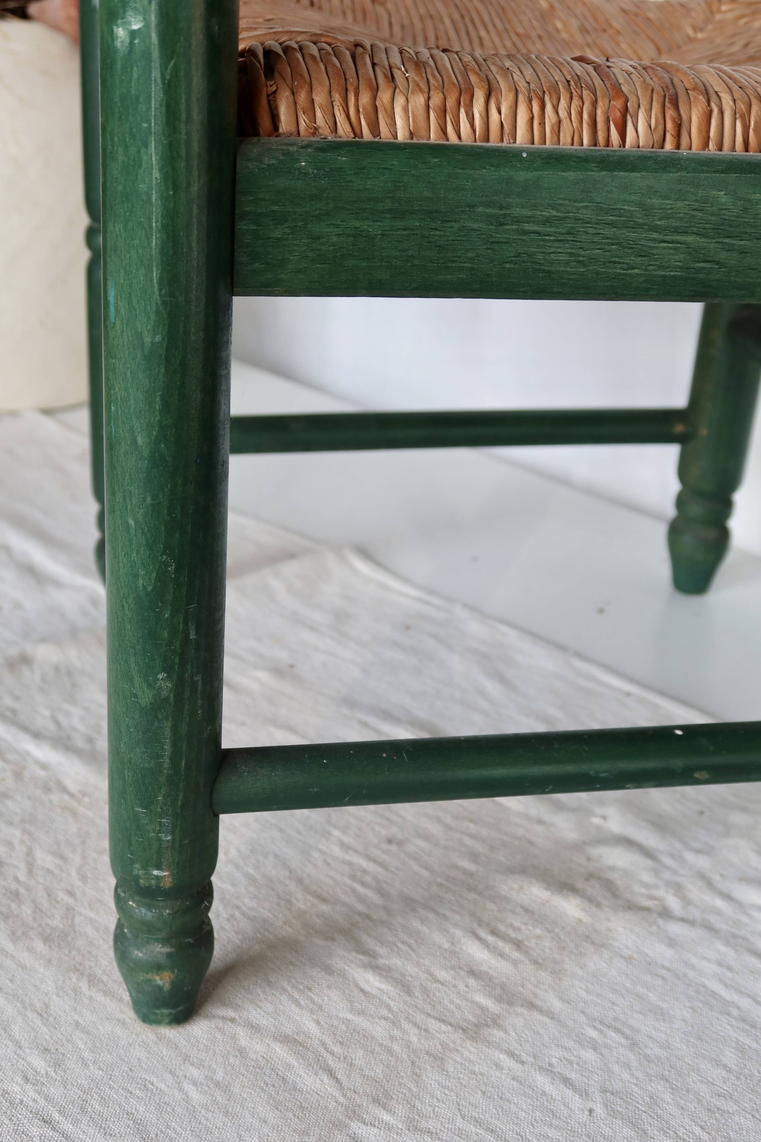Vintage children's chair in green wood with a woven straw seat