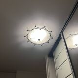 Round ceiling light with a wrought iron frame.