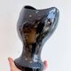 Black ceramic vase with a woman's face.