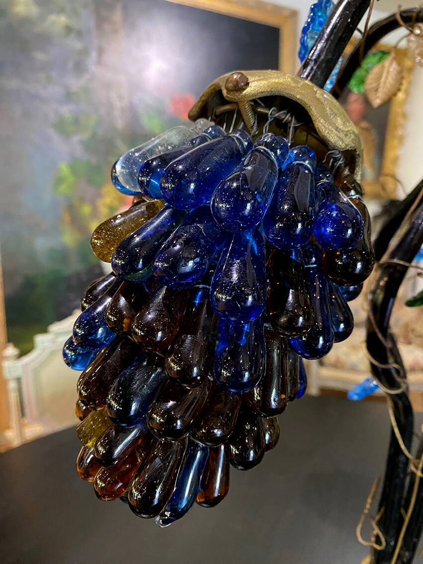 Table lamp with four light arms and globes shaped like bunches of grapes.
