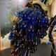Table lamp with four light arms and globes shaped like bunches of grapes.