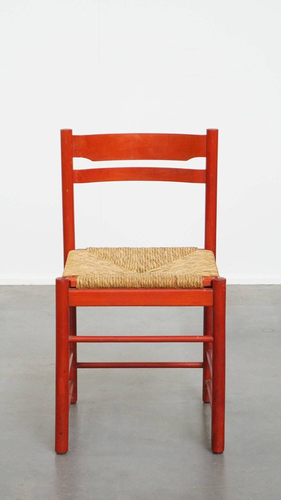 Vintage 1970s red wooden chair with a woven wicker seat