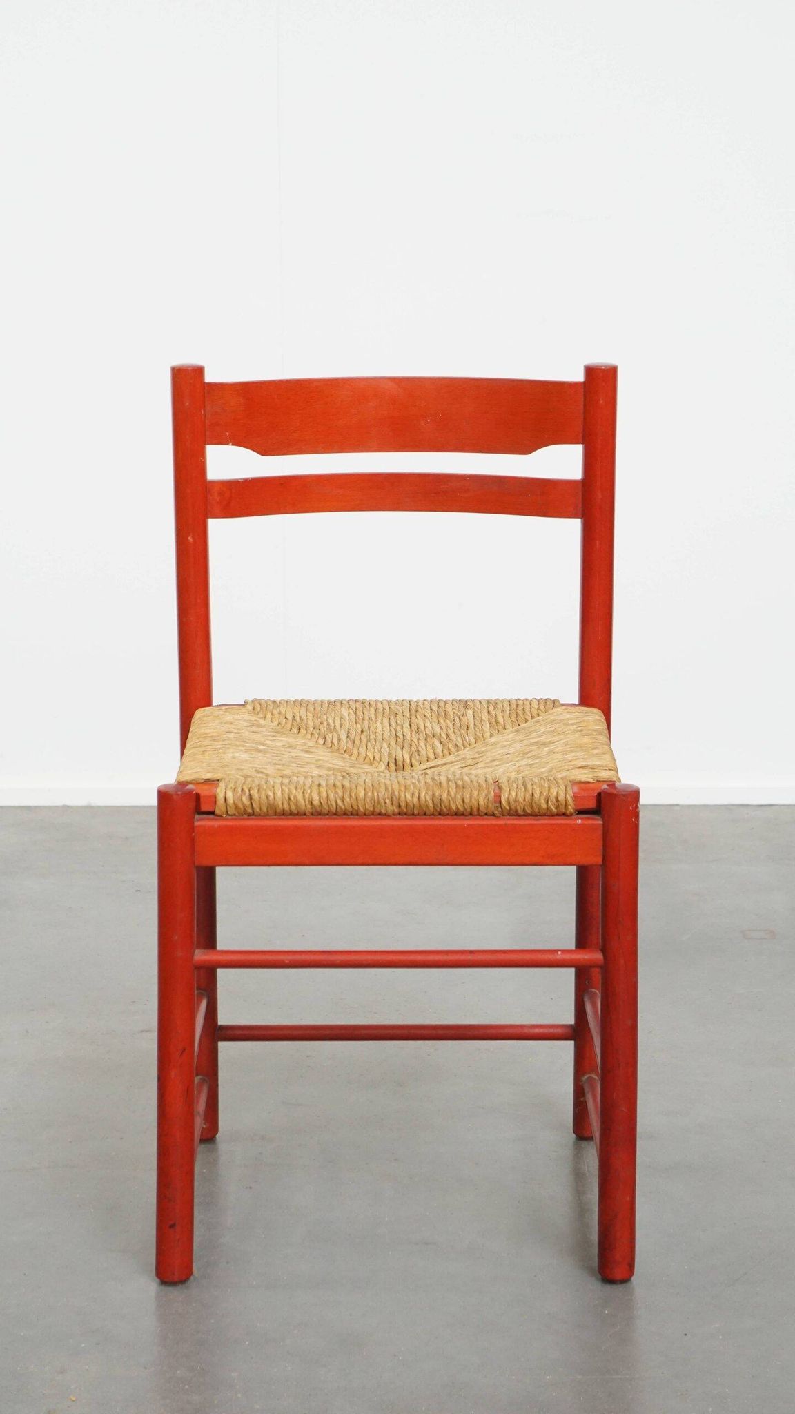 Vintage 1970s red wooden chair with a woven wicker seat