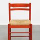 Vintage 1970s red wooden chair with a woven wicker seat