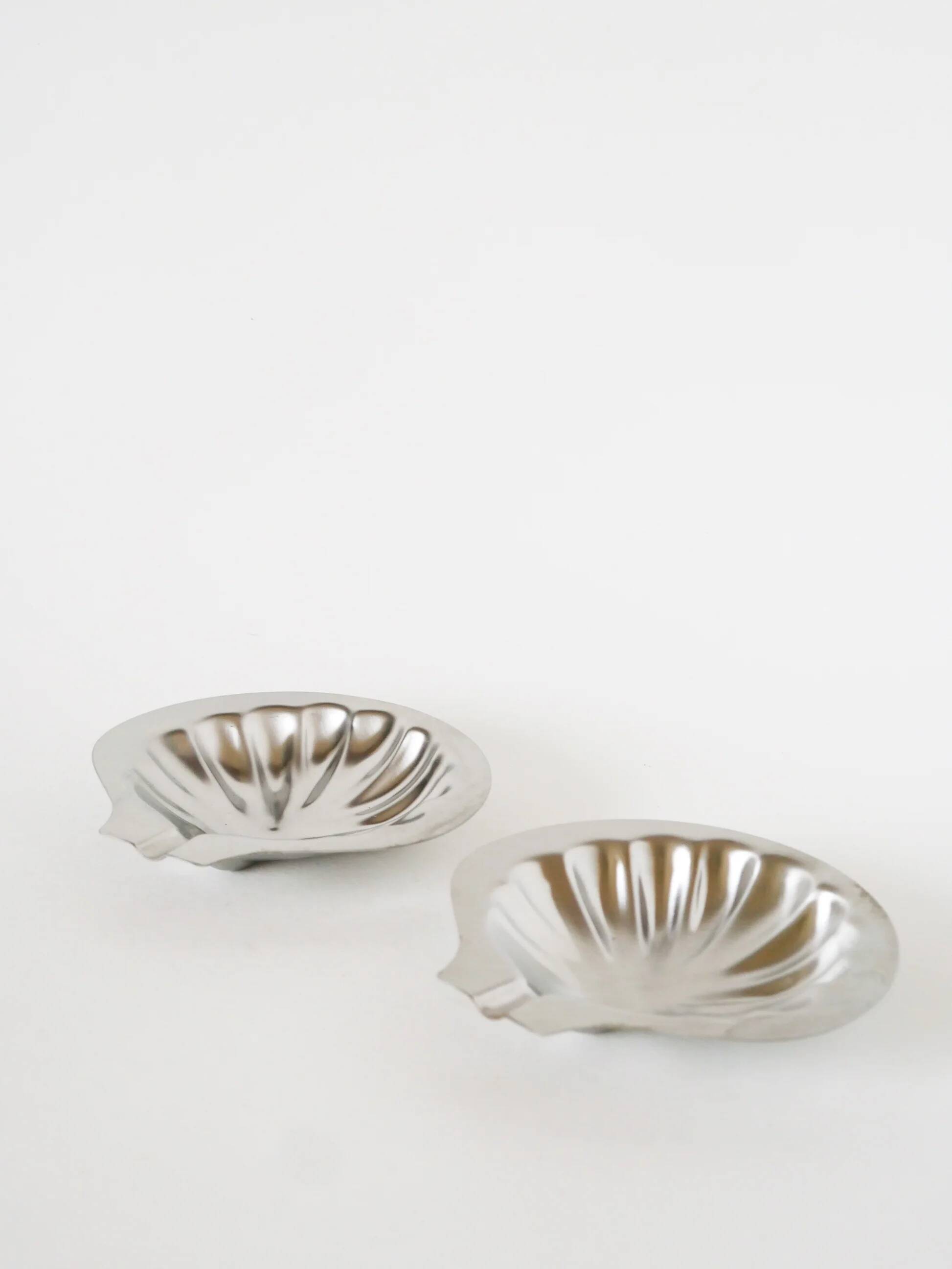 Pair of shell-shaped stainless steel catchalls, design, 1970