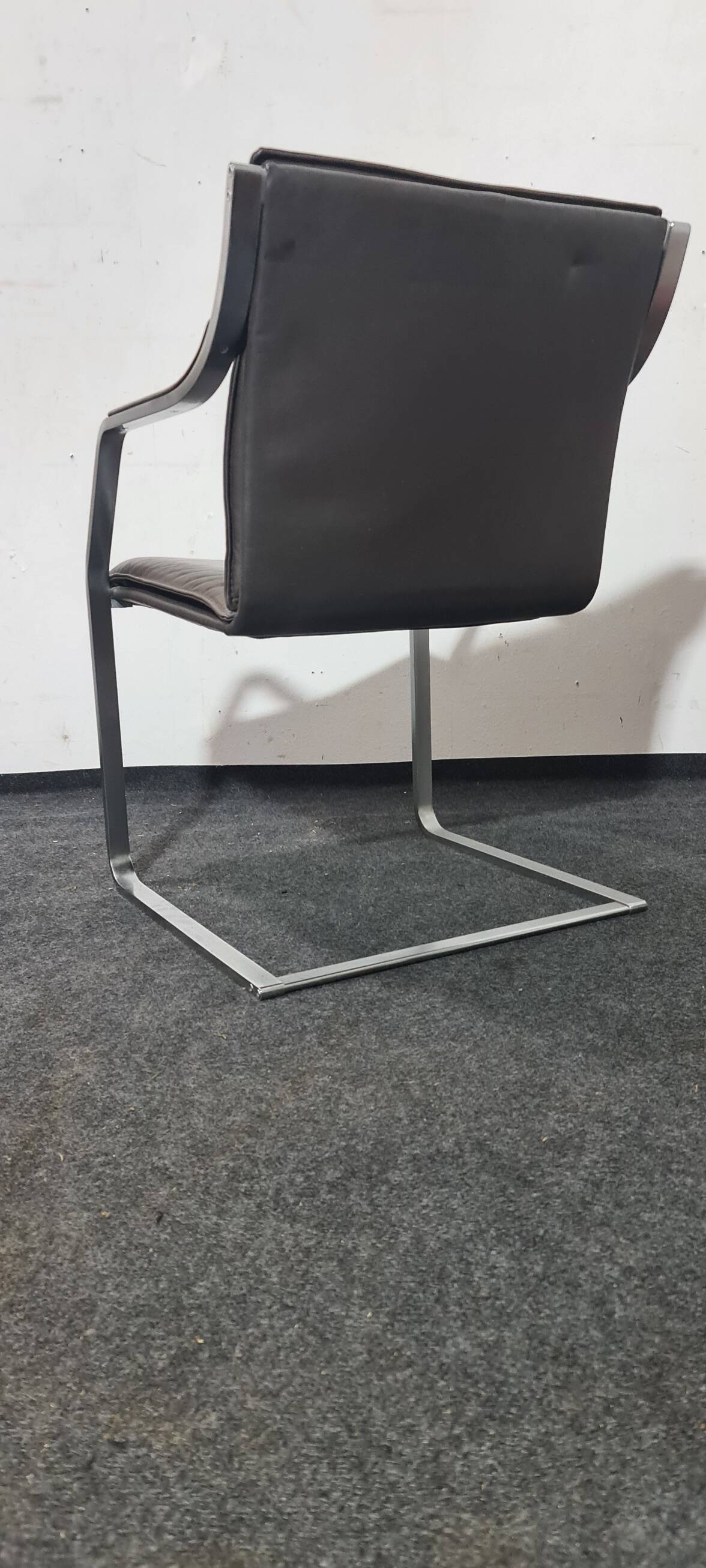 One of two vintage Leather and metal arm chairs.