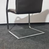 One of two vintage Leather and metal arm chairs.