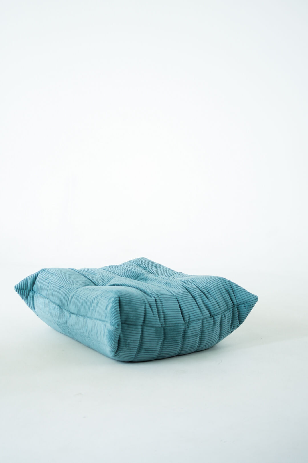 Ensemble de fauteuil et pouf Togo en velours côtelé bleu clair.