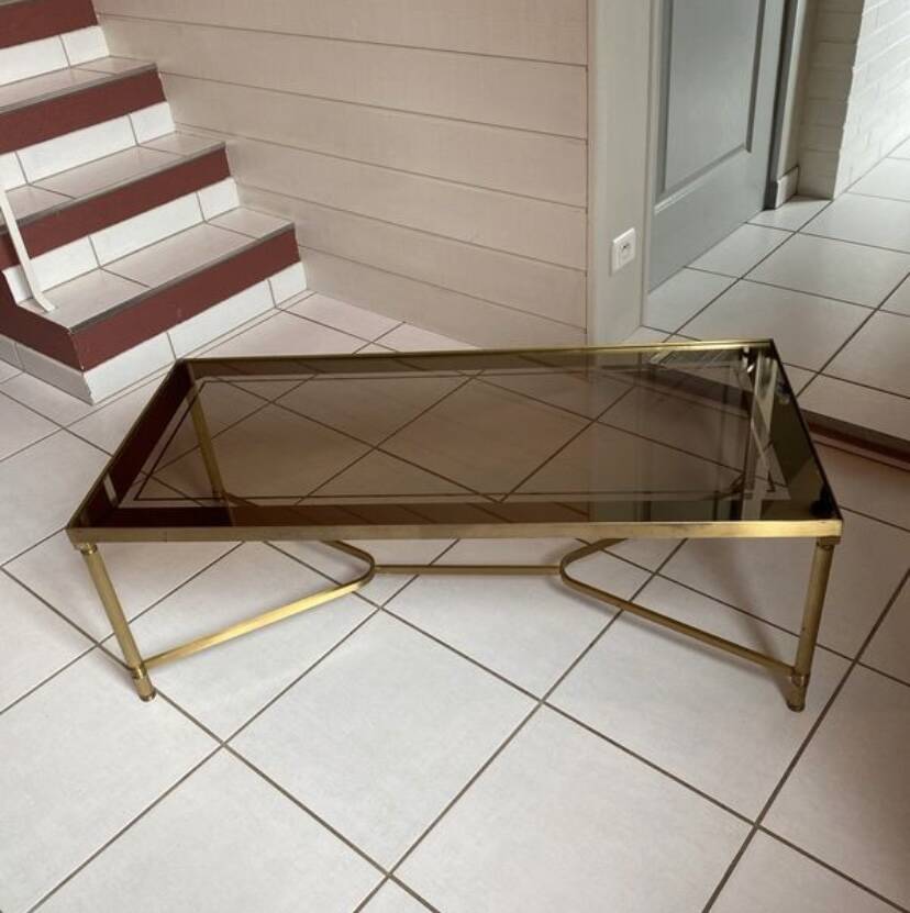 Rectangular neoclassical coffee table in gilded brass with a glass top.