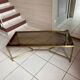 Rectangular neoclassical coffee table in gilded brass with a glass top.