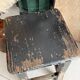 Solid wood stool with a worn black patina.