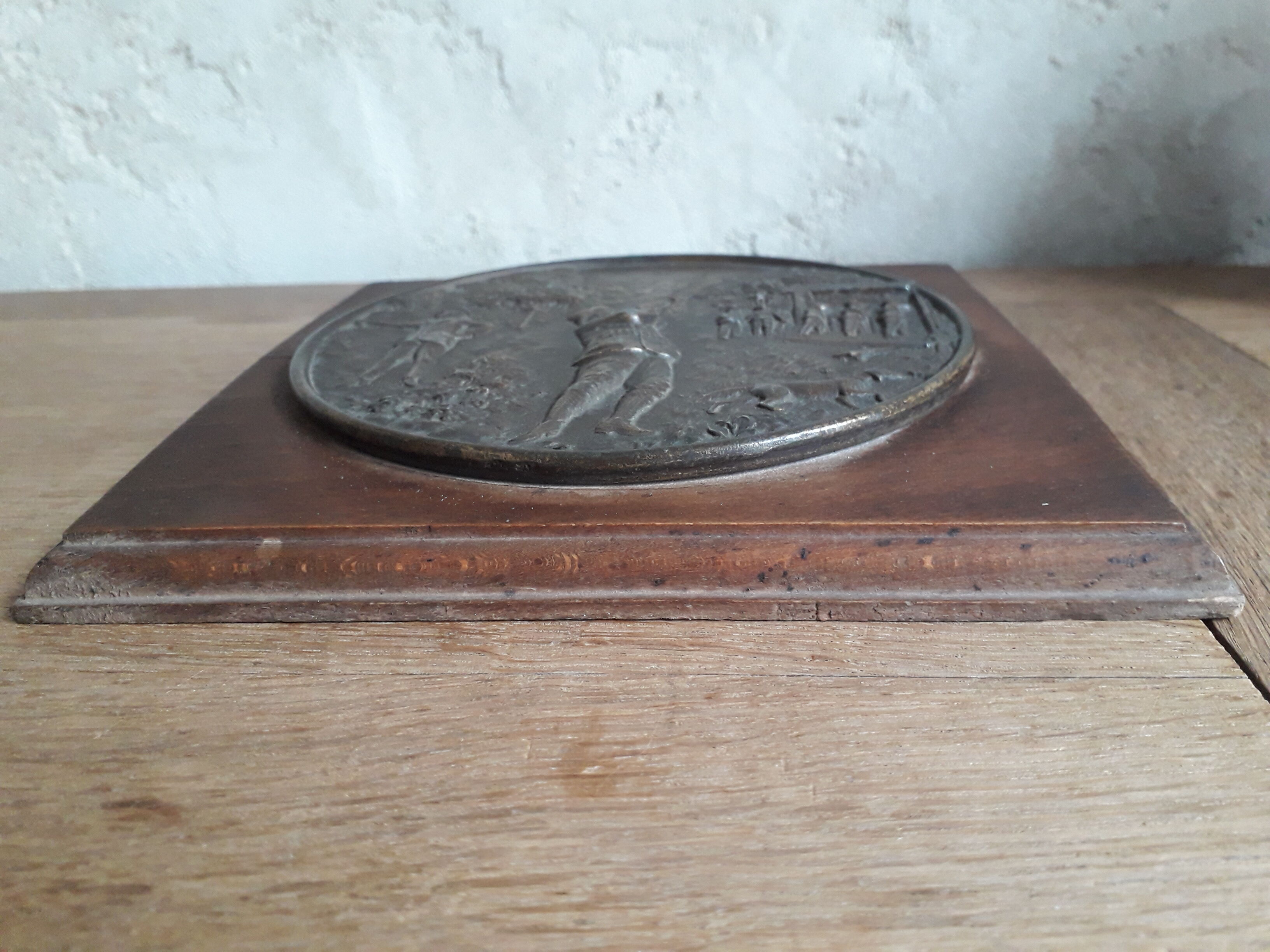 Médaillon en régule sur plaque de bois scène de chasse