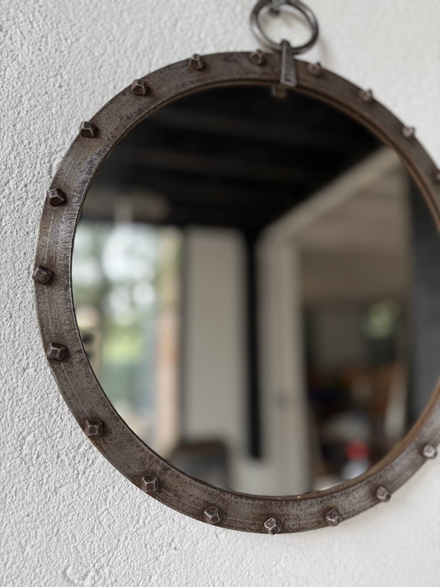 Brutalist round mirror with wrought iron and studs.