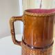 Antique vintage ceramic pitcher or jug from Sarreguemines, France. Brown with a pink interior, imitation basket.