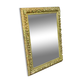 Important Louis XIV mirror richly carved with flowers in gilded wood