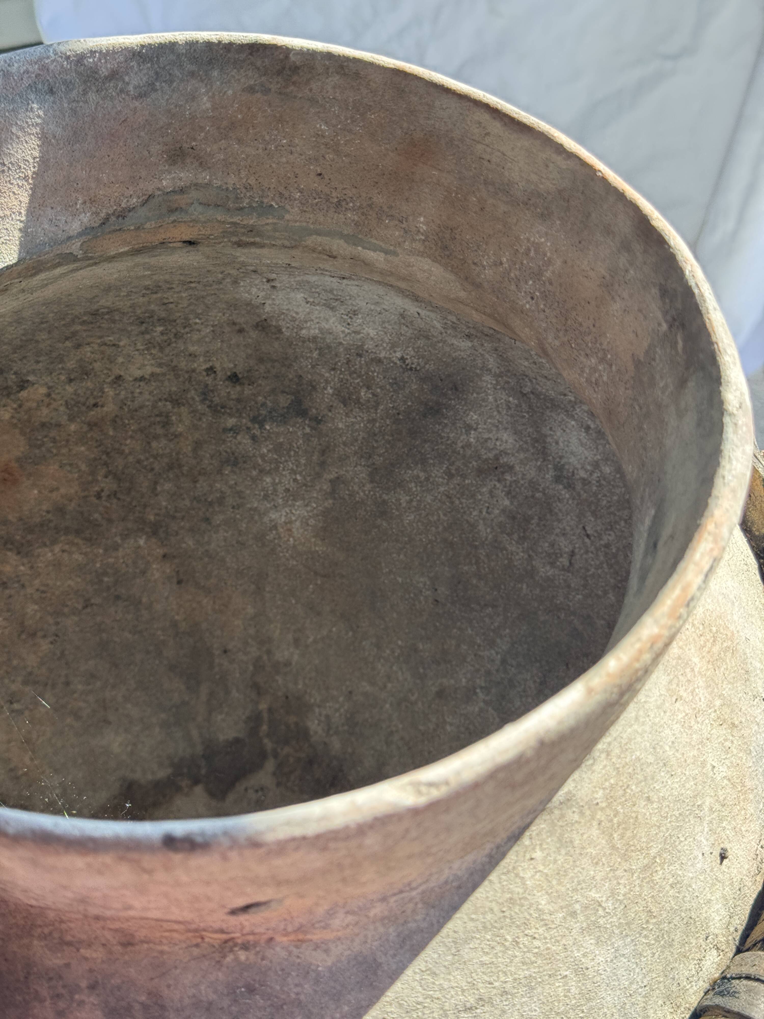Very large light grey terracotta pot with handles and rattan crossbars.