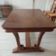 Solid wood dining table with a sculptural base.