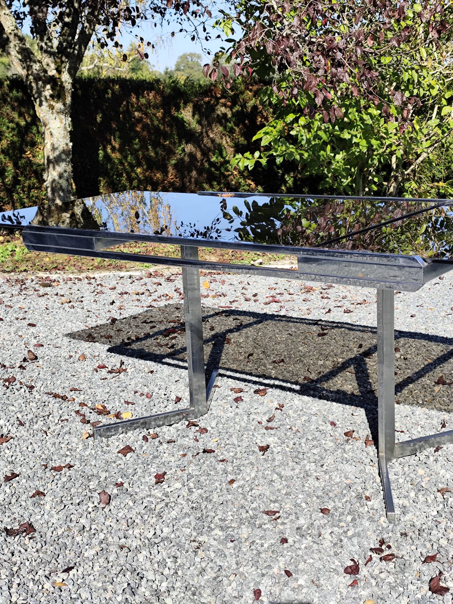 Table pietement chromé et verre fumé année 70 avec allonges