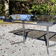 Table pietement chromé et verre fumé année 70 avec allonges