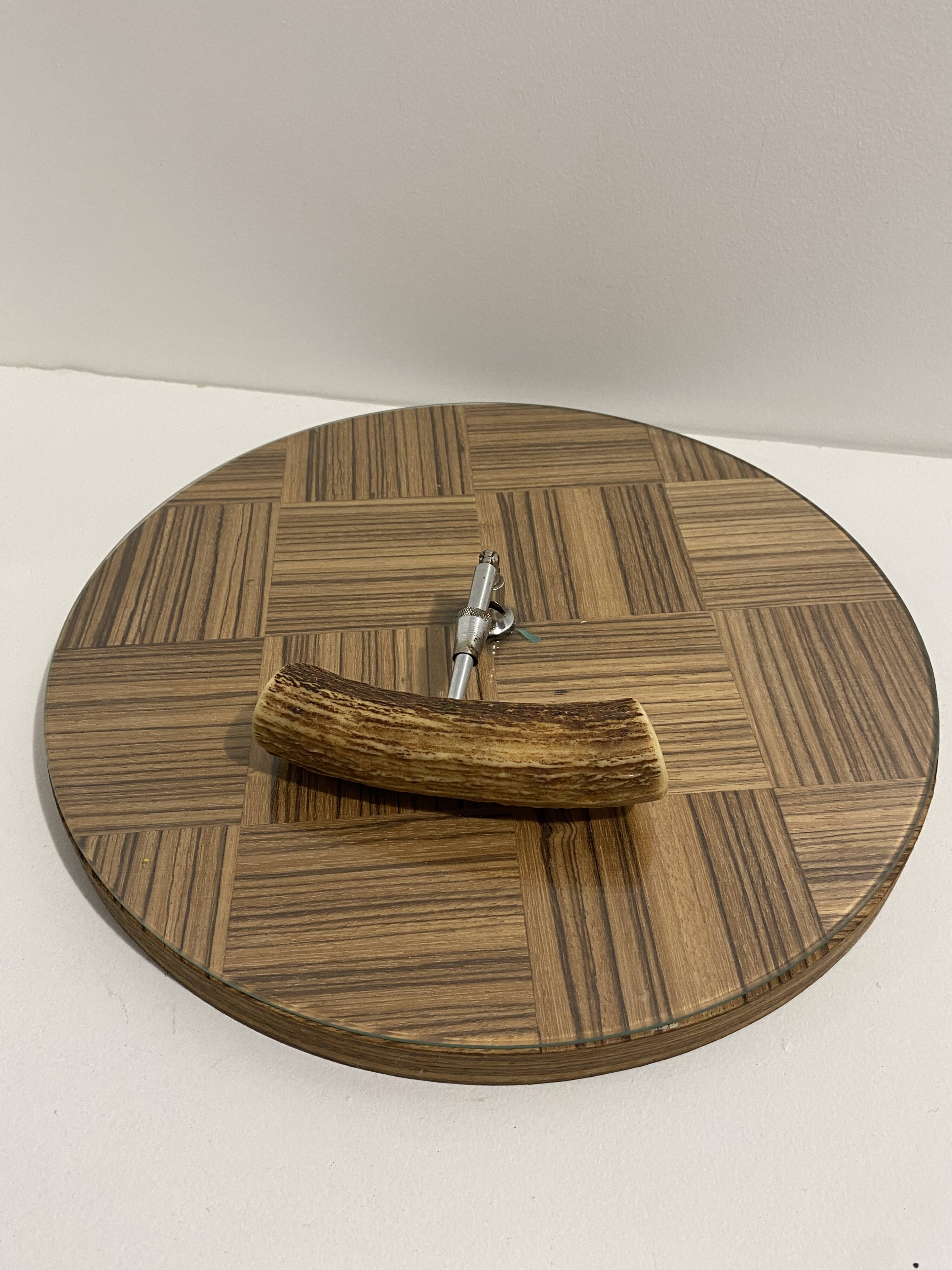 Vintage round wooden cheese board covered with glass plate with foldable handle