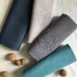 Set of four old damasked and monogrammed napkins, dyed in multiple colors