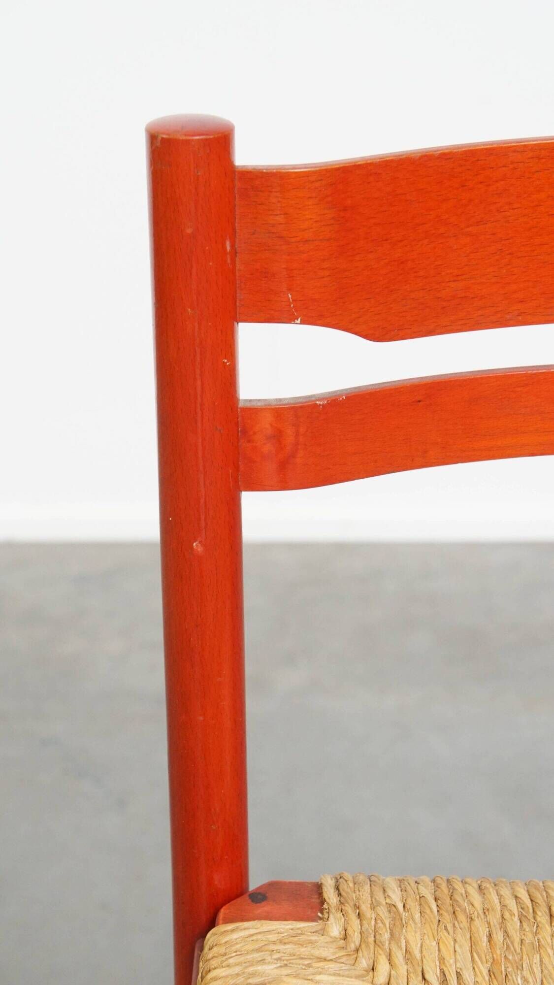 Vintage 1970s red wooden chair with a woven wicker seat