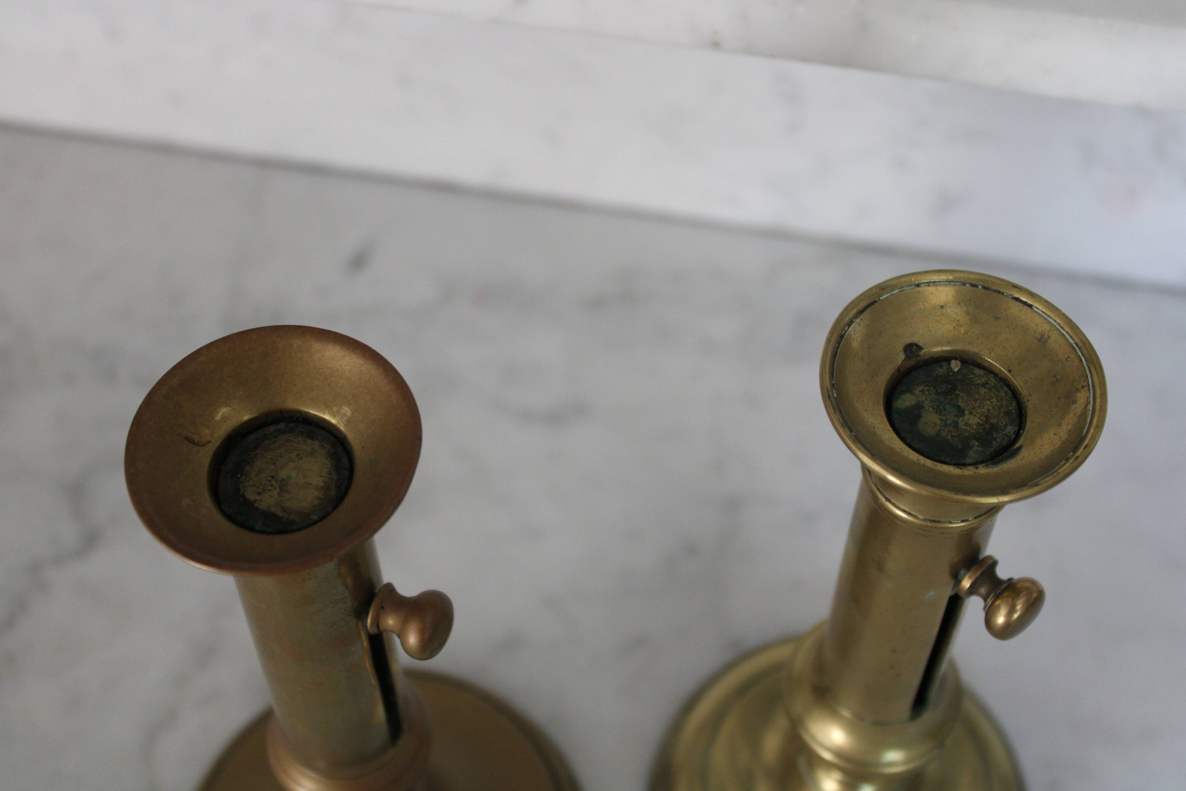 Pair of brass pusher candlesticks