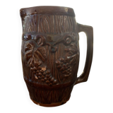 Hungarian folk ceramic pitcher with a brown glossy finish and relief decoration of vine.