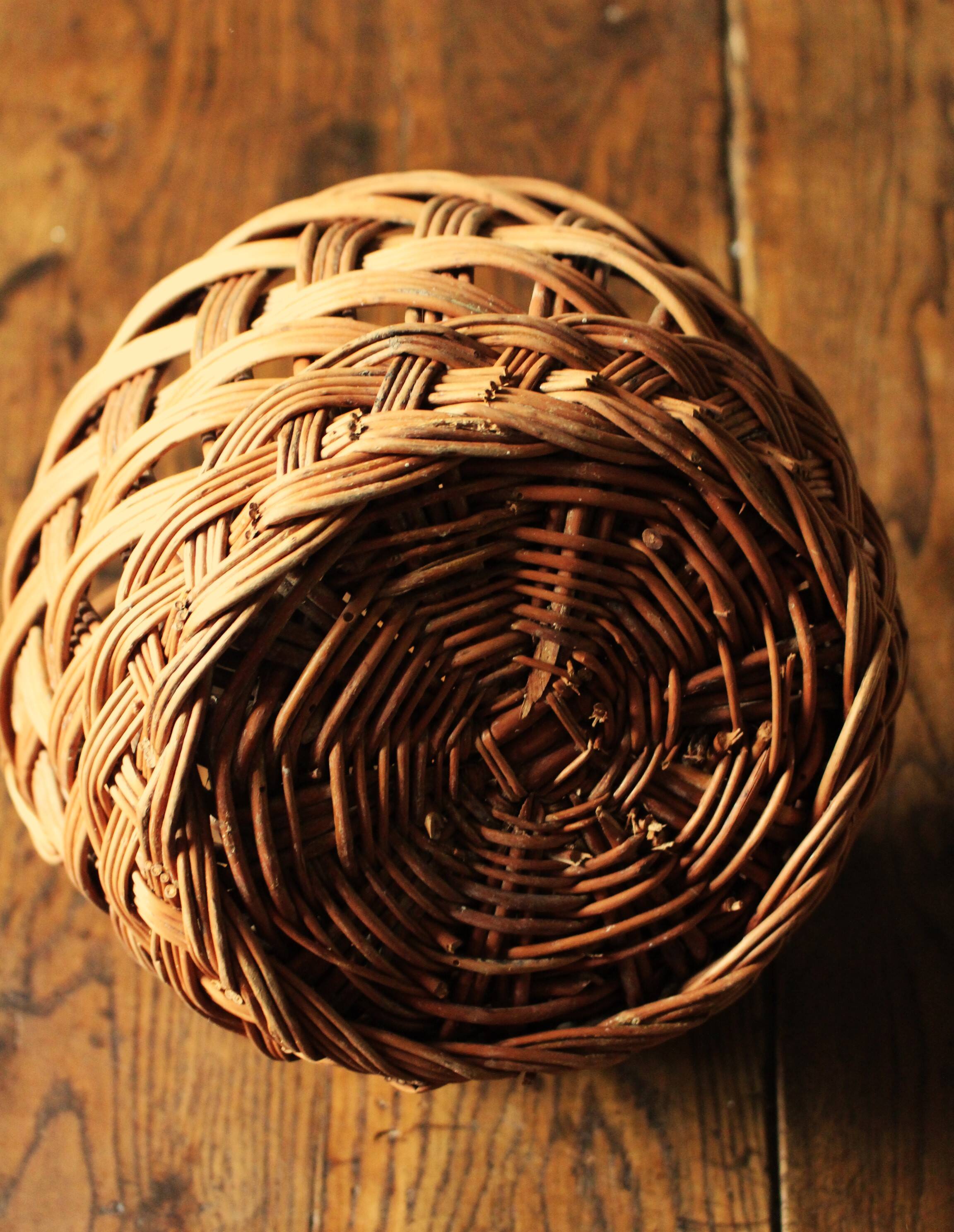 Round woven dark wicker basket with openwork vintage handle